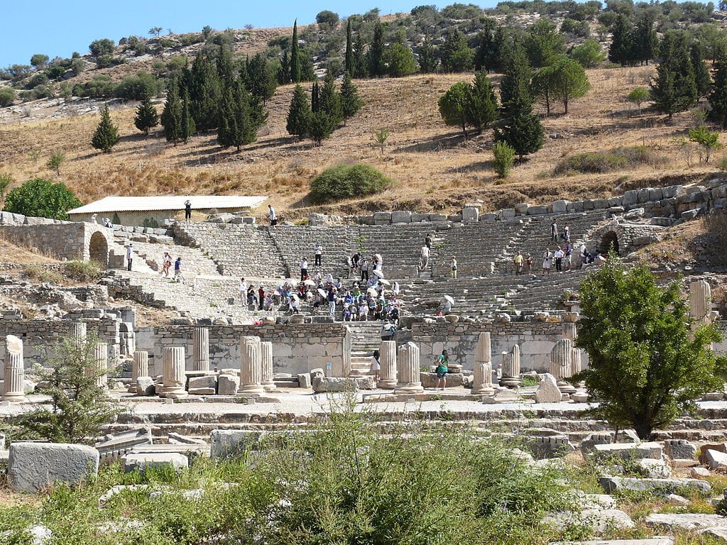 had a capacity of 1500 spectators. It had 3 doors opening from the stage to the podium. The podium was narrow and one meter higher than the orchestra section. The stage building was two-storeyed and embellished with columns.  