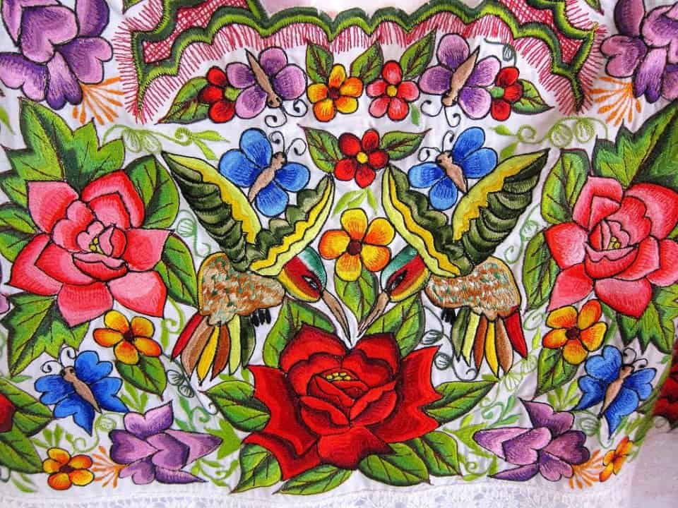 close up of embroidery of colourful flowers on a Mexican embroidered dress traditionally worn in the Yucatan