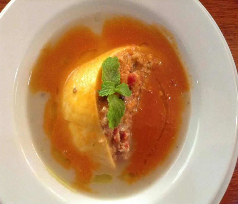 Queso Relleno a rind of cheese stuffed with meat and spices with a light tomato broth.