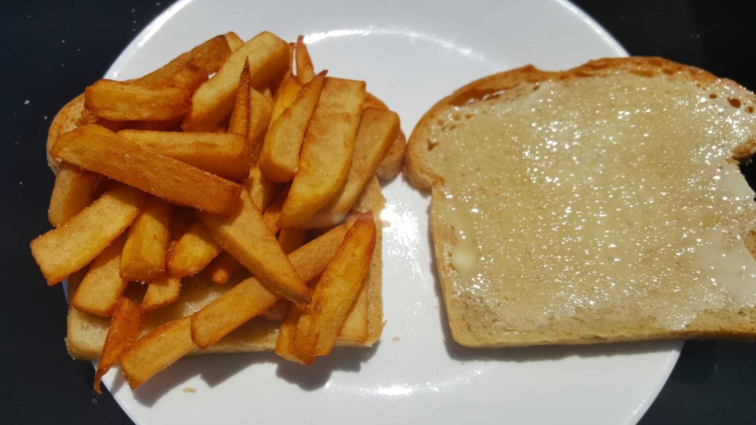 French fries or chips are served on lavishly buttered bread