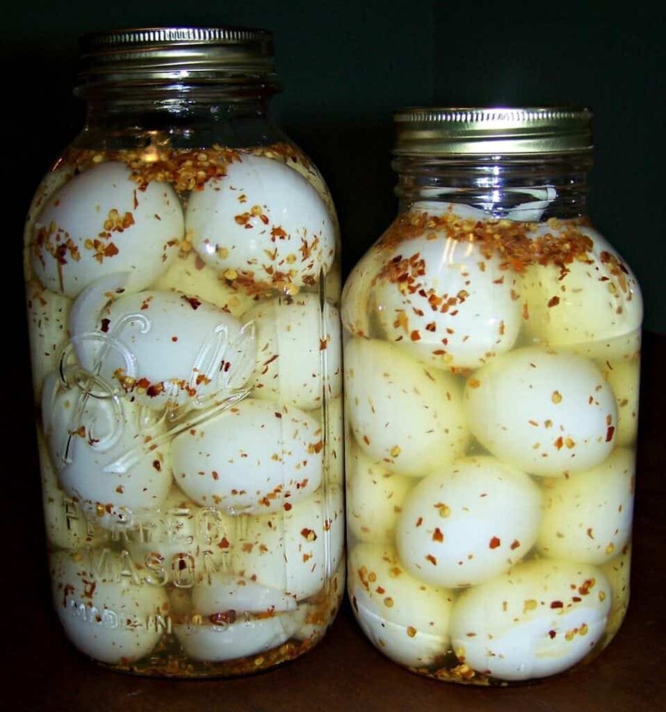2 jars of pickled eggs sit on a counter