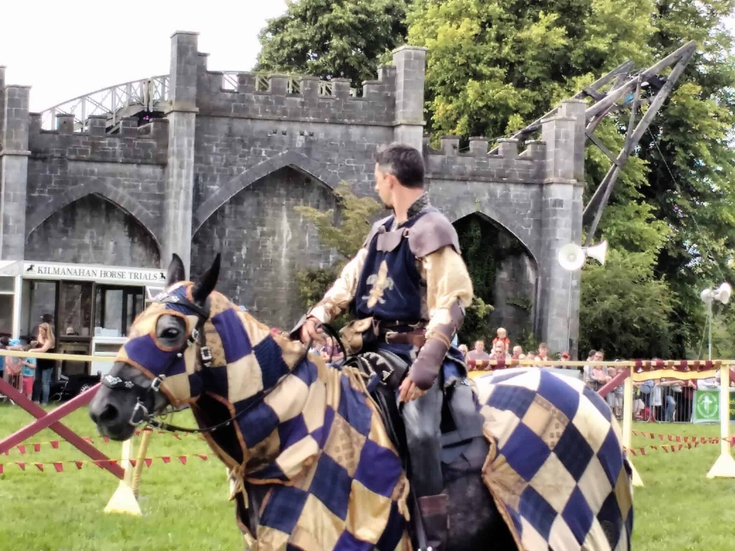 Jousting at Birr Castle Ireland, the Knight on horseback is equipped with his armour with a french fleur di lis on the front of his tabard. The horse has a blue and white checkered blanked