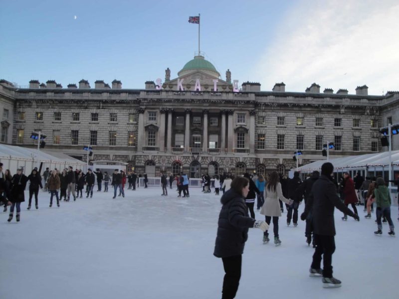 The Somerset House Christmas skating rink. The rink is in front of a very grand English Mansion with hundreds of windows and people skating