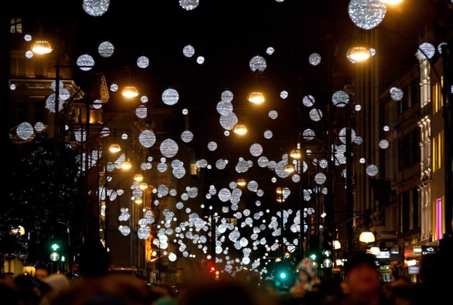 The Christmas lights of oxford street. The lights are small balls almost like planets hanging over the streets while shoppers run in and out of the stores