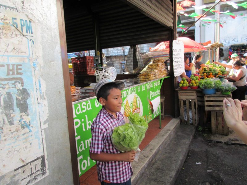 boy selling lettuce at the Lucas Galvez Market in Merida