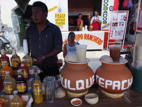 Mexicos best drinks - pulque and tepacce vendor in the Yucatan. A road side stand with terracotta pots full of pulque and tepache to be served to customers.