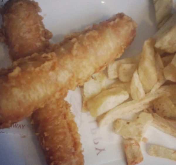 a plate of battered sausages and chips traditional British foods