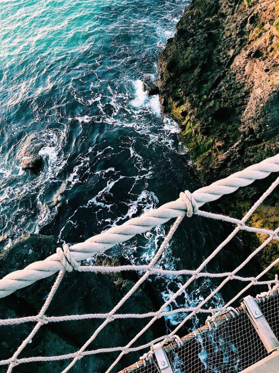 Carrick-a-rede rope bridge on the Causeway Coast a view from the middle of the bridge looking down into the storm Atlanic