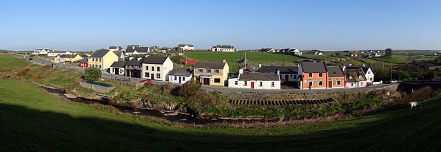 Tourists between the colored houses of the Doolin village Ireland travel guide