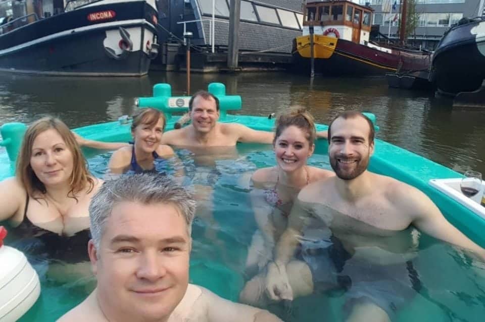 Best Cities to visit in the Netherlands hot tubbing boat on the canals of the Netherlands