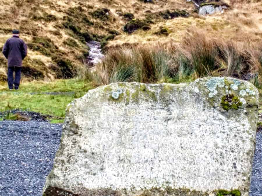 a large stone with faintly engraved gaelic in Glenveagh National Park - a memorial to those escaping the famine this is the place where their families said there last goodbyes