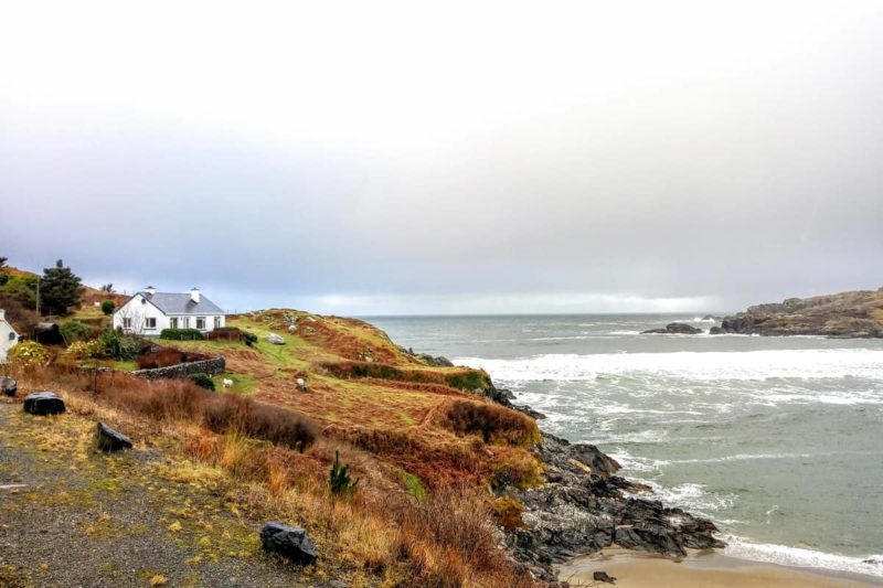 Green Bay Beach in Glencolmcille with a house perched high on the hills surrounding the bay