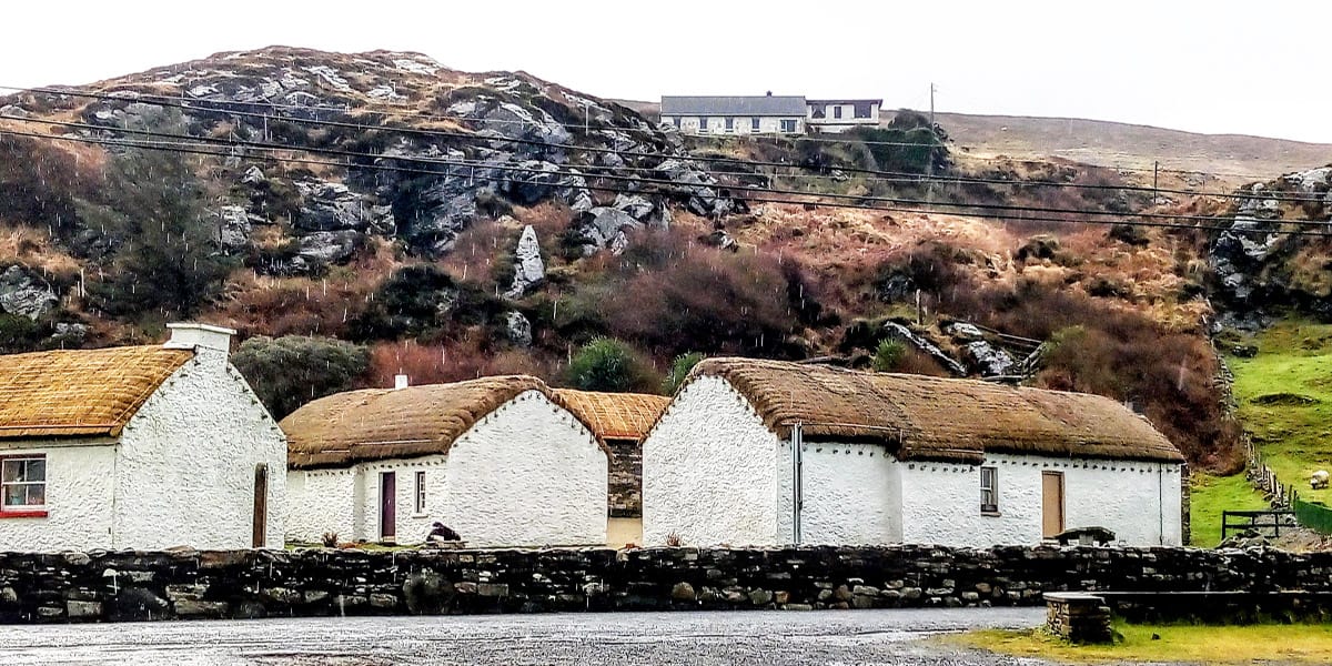 a row of cottages at the Glencolmcille Folk Village showing how the thatch is attached