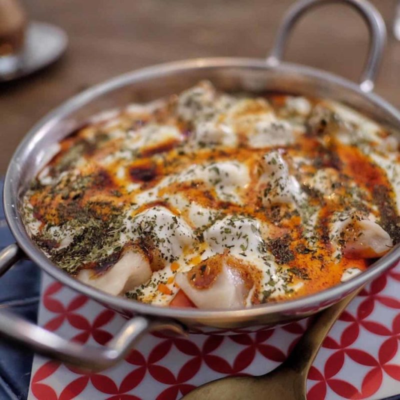 A pan with a dish of Turkish food on a table.