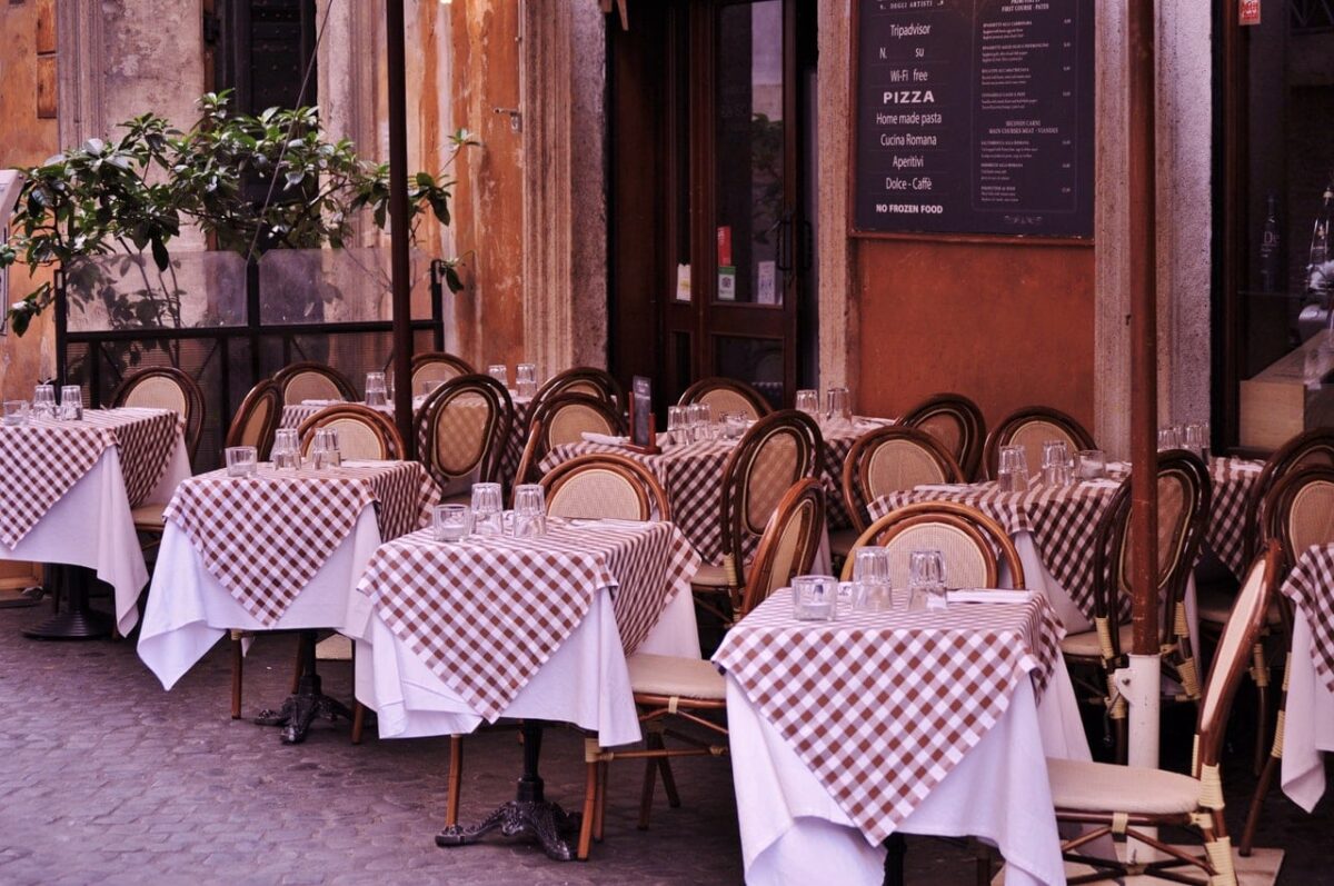 All the best places to eat in Rome view of a Roman restaurant with checked tablecloths al fresco