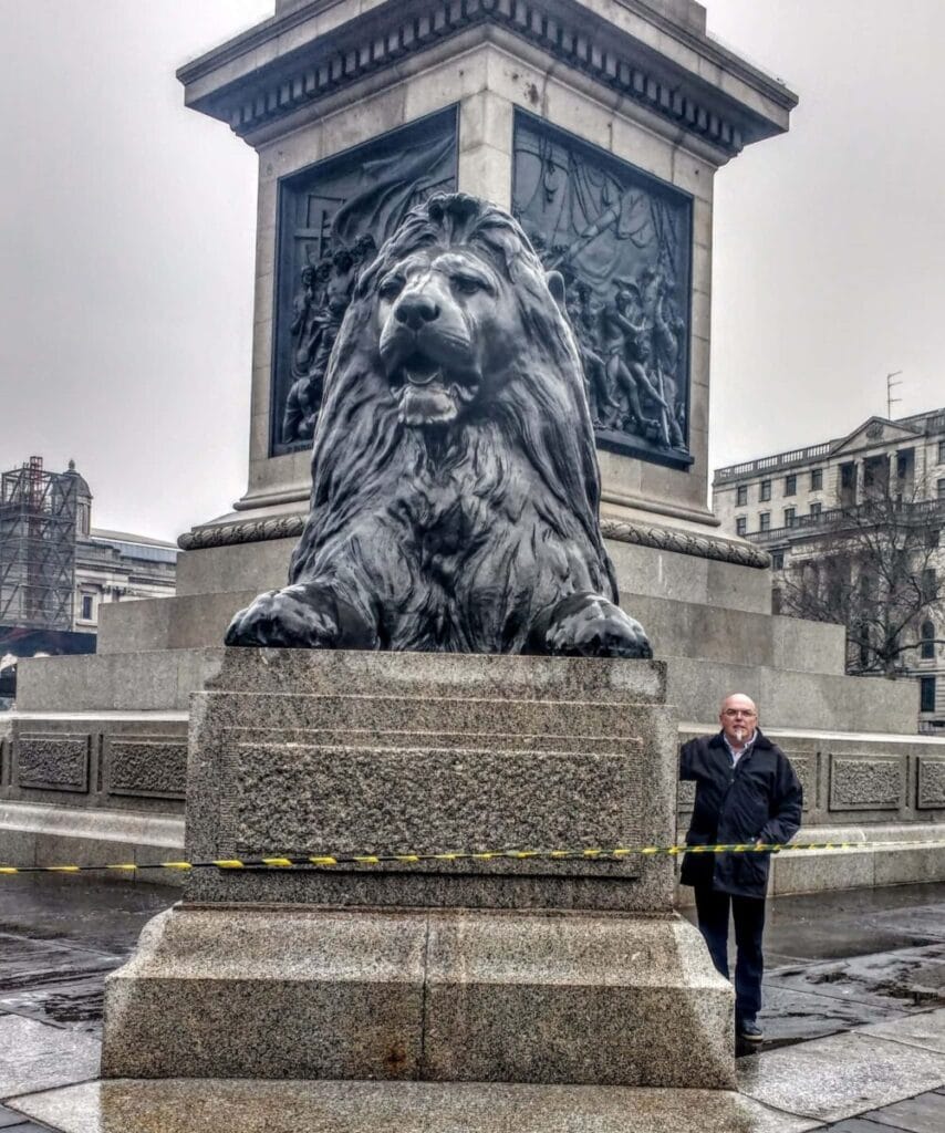 Trafalgar square lion on a massive plinth in front of Nelsons statue