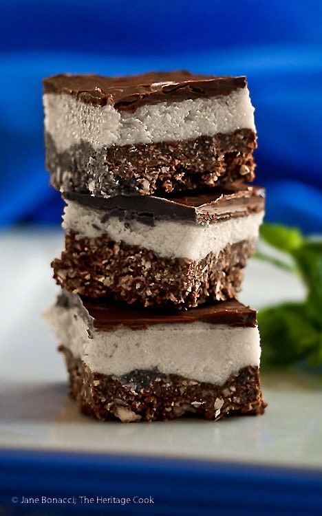 A Canadian Nanaimo bar that has three layers. The bottom layer is a chcolate cracker base with coconut, the second layer is a soft custard cream and on top a chocolate ganache
