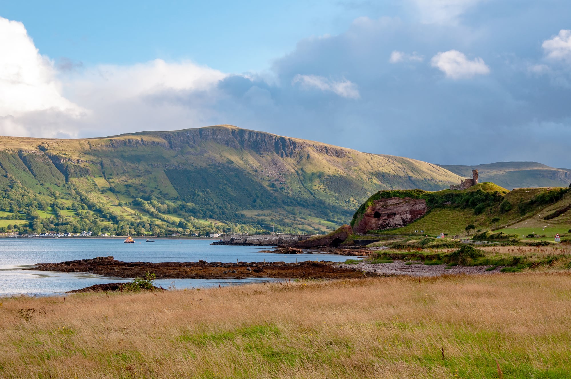 a view across the bay and the Glens with the ruined Red Bay Castle sitting on a hilltop