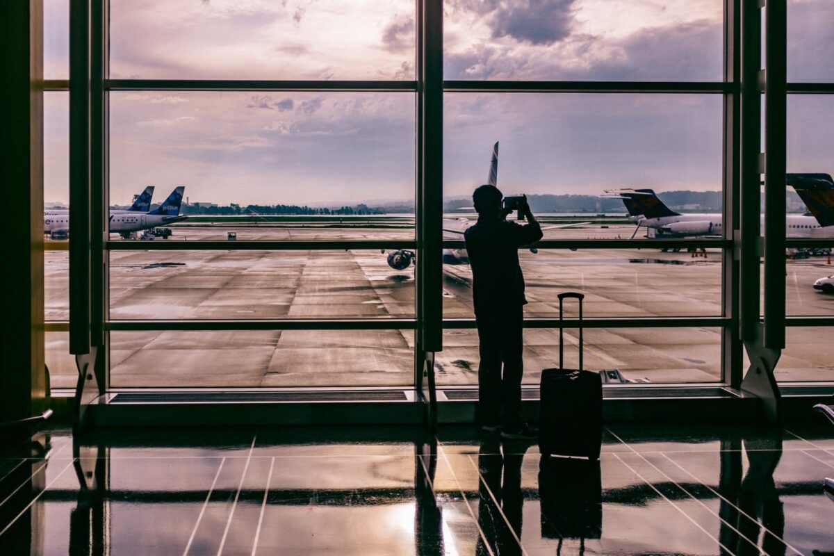 ESTA online man taking a photo of planes landing at an airport
