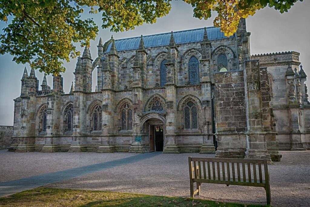 Rosslyn Chapel, located in Scotland, is a stunning 15th-century Gothic chapel renowned for its intricate stone carvings, including elaborate foliage patterns, intricate arches, and mysterious symbolic figures, all set within a compact, atmospheric structure with a richly decorated interior and a sense of historical and mystical allure.