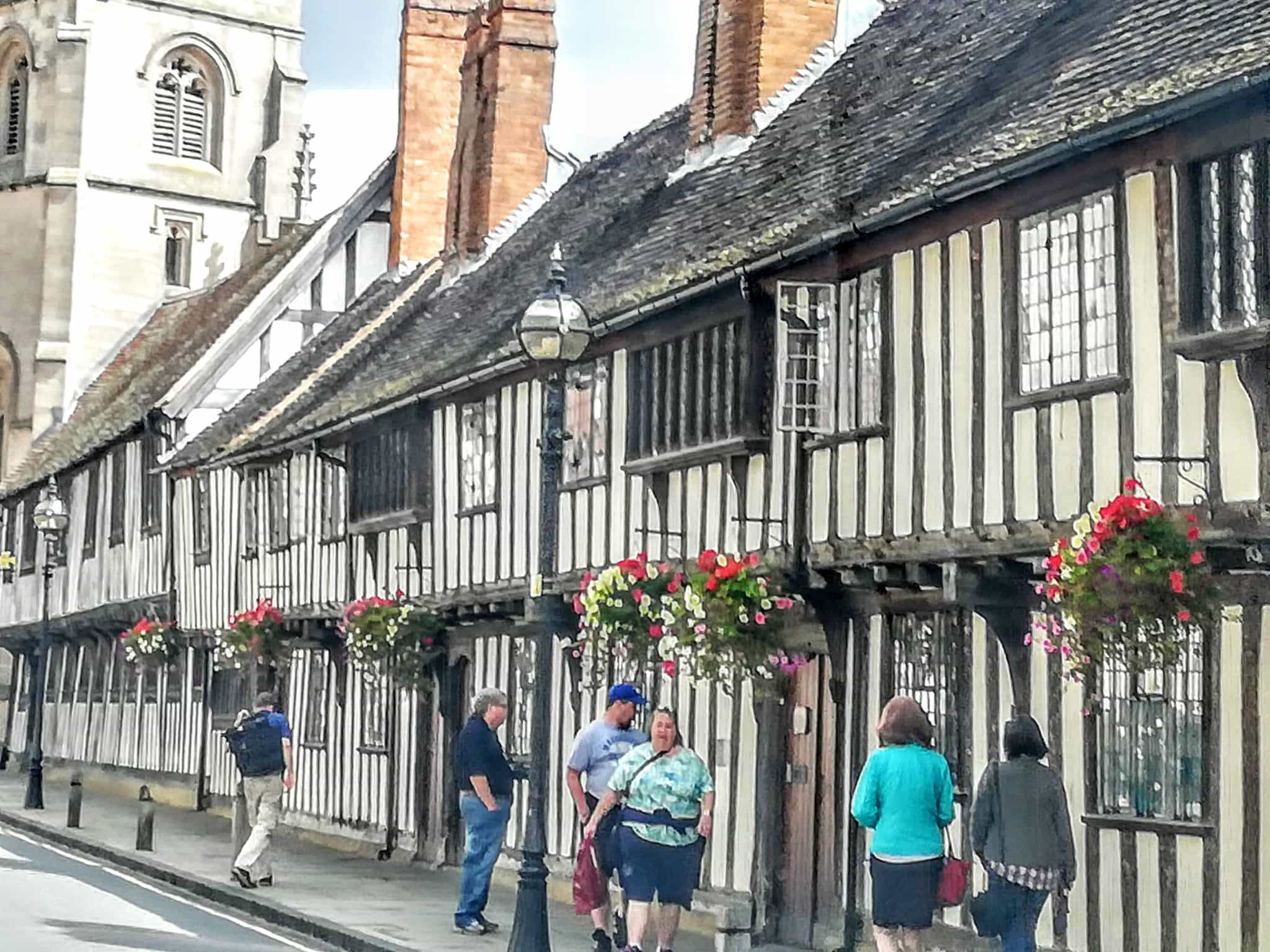 The famous almshouses of Stratford built in the 15the century. They are white buildings with black timbered beams and leaded glass windows