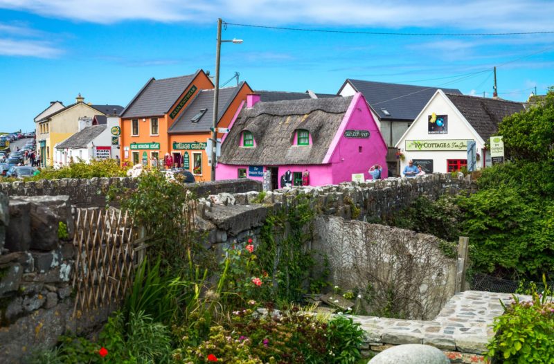 Galway, Ireland - August 4, 2013: Tourists between the colored houses of the Doolin village Ireland travel guide