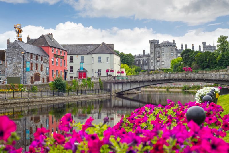 beautiful flower lined riverside view of kilkenny castle town and bridge