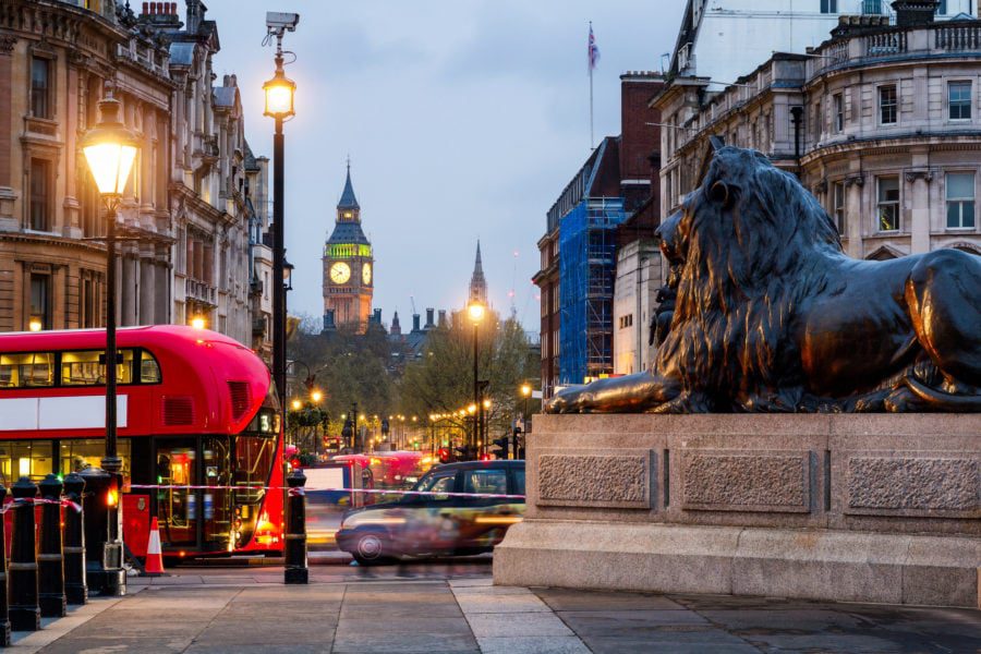 Trafalgar Square Lions with London buses and Big Ben in the background