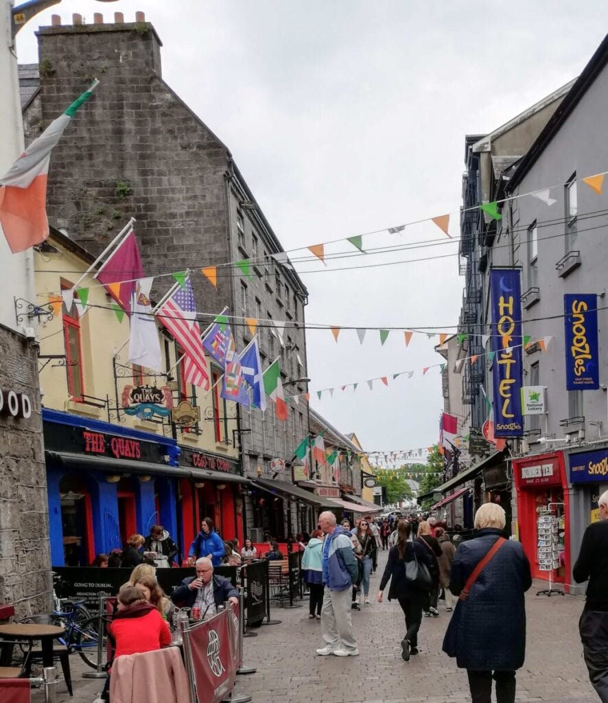 Street in Galway with pub, shops and the street is hung with coloured flags and bunting