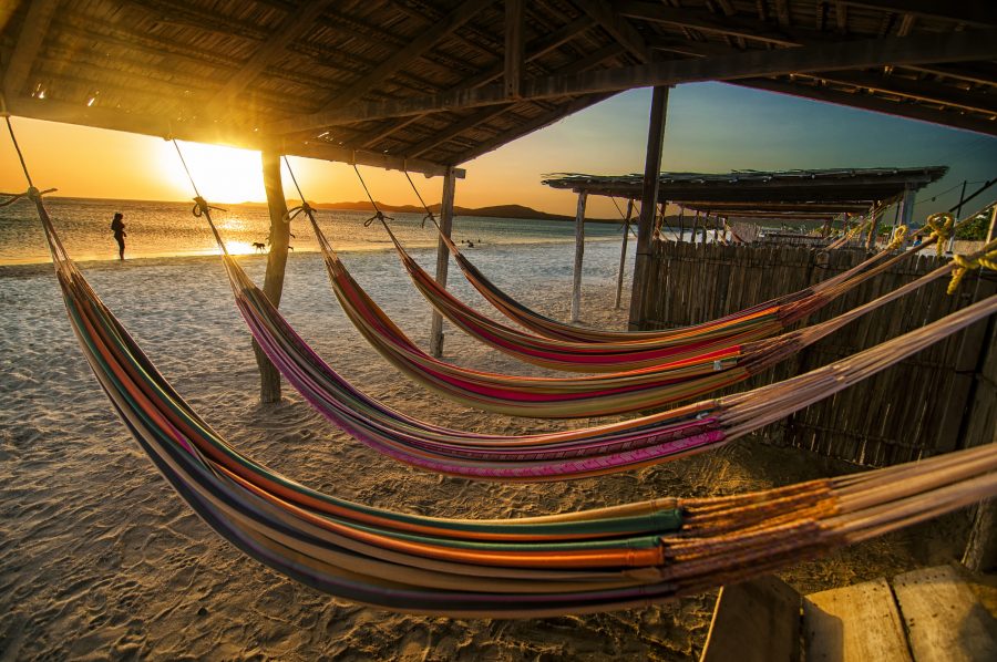 hammocks on the beach of Mexico as the sunsets across the waters