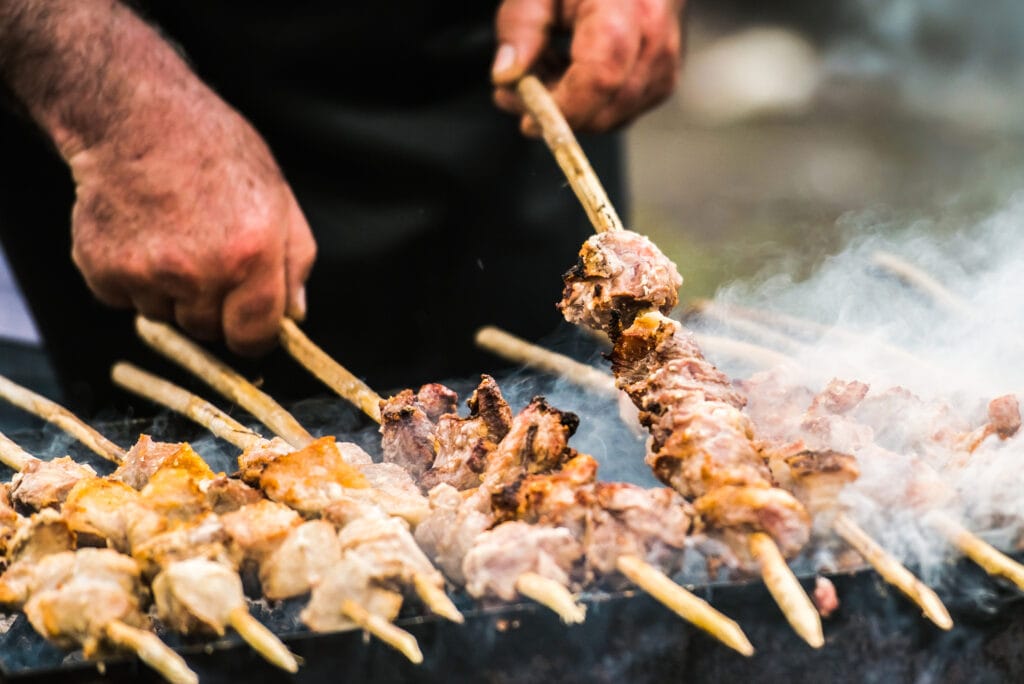 Preparation of barbecue on grill. Roasted meat slices shashlik. Selective focus and shallow DOF