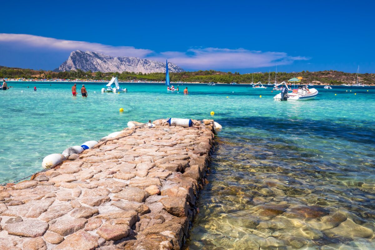 CALA BRANDINCHI, SARDINIA - August 2017 - Cala Brandinchi beach with Isola Travolara in the background, red stones and azure clear water, Sardinia, Italy.