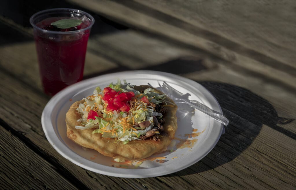 Traditional Indian Taco made of fry bread and beef and a Native American blackberry sage ice tea with fresh berries and sage at powwow, San Francisco
