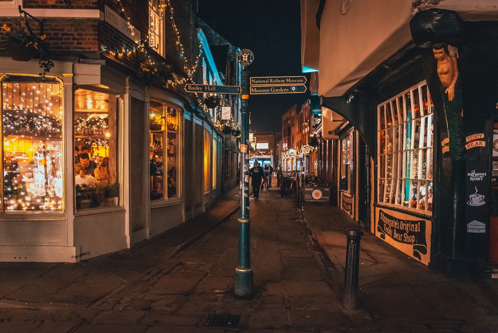 YORK, ENGLAND, DECEMBER 11, 2018: People walking in the beautiful medieval streets of city of York, United Kingdom, surrounded by the old city wall.