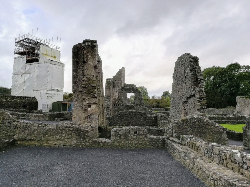 repairs and reconstruction of Kells Priory with white clad structural supports around a ruined tower