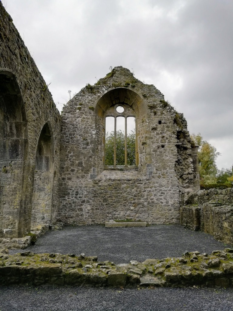 Ruined wall of Kells Prior shows the arched window frame that would have had stained glass inserts in it.