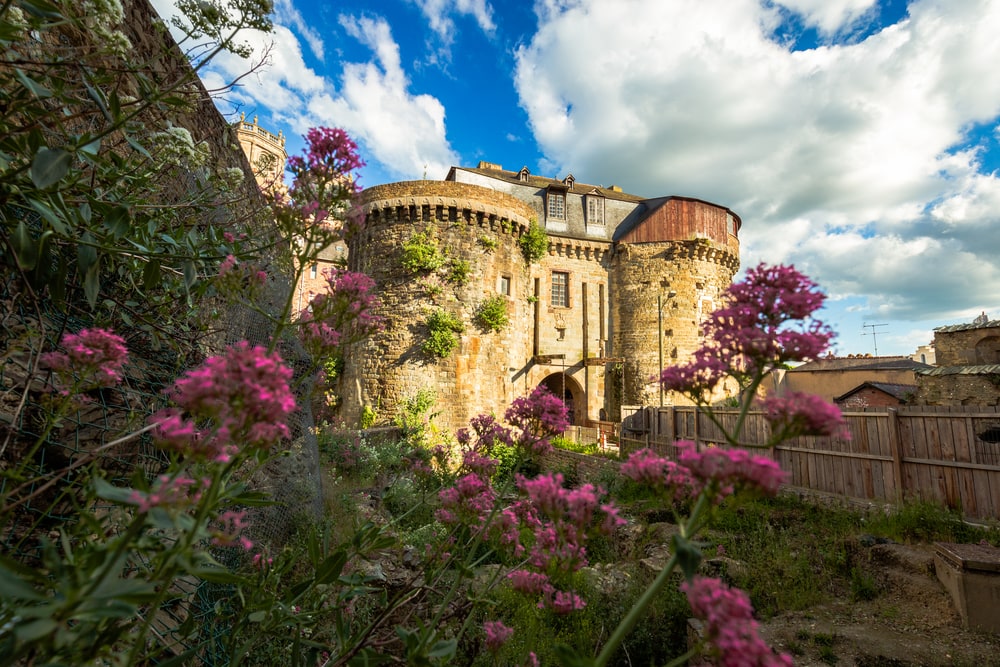 Beautiful medieval towns in Europe the ancient gates to the City of Rennes in France with purple flowers