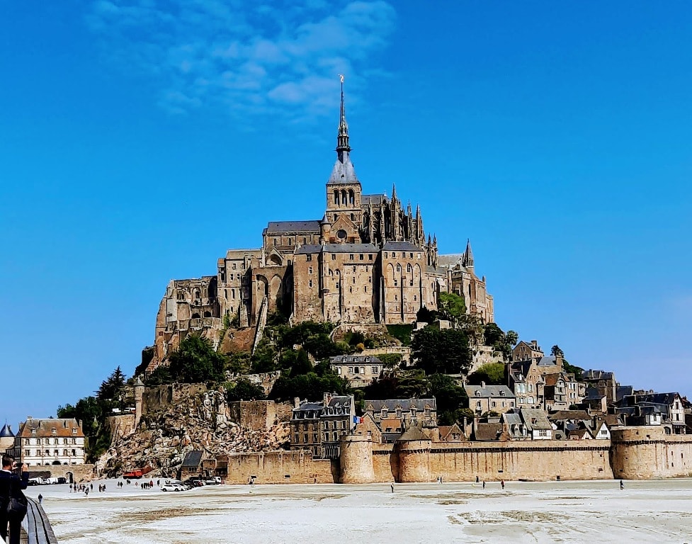 visiting Mont St Michel, an image of the island with the 1300 year old abbey rising from the top of the island
