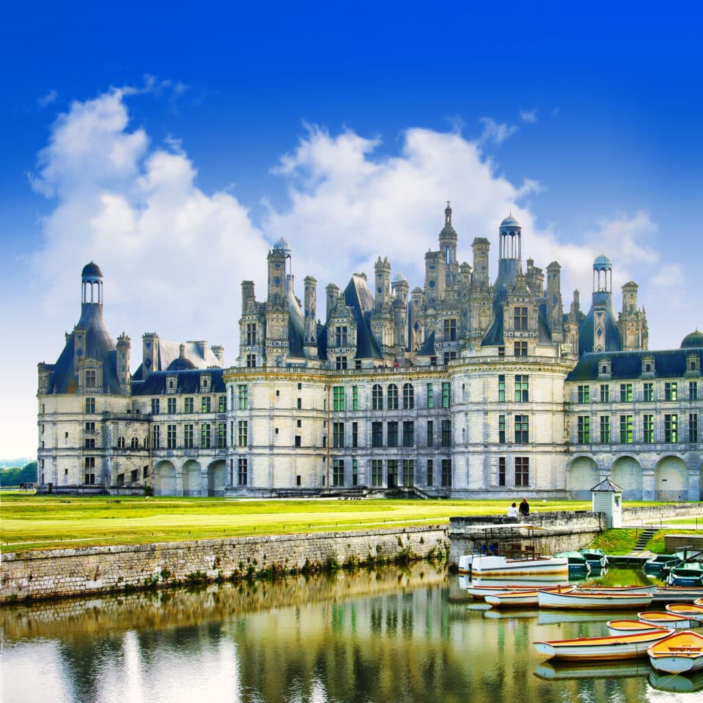 Chateau de Chambord along the river with the electric boats to tour the Loire river and view the chateau from the water