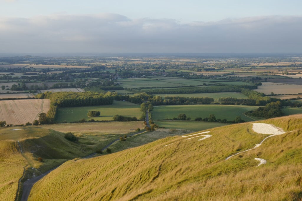 English countryside view from White Horse Hill Uffington stretching out with small fields and grasslands.