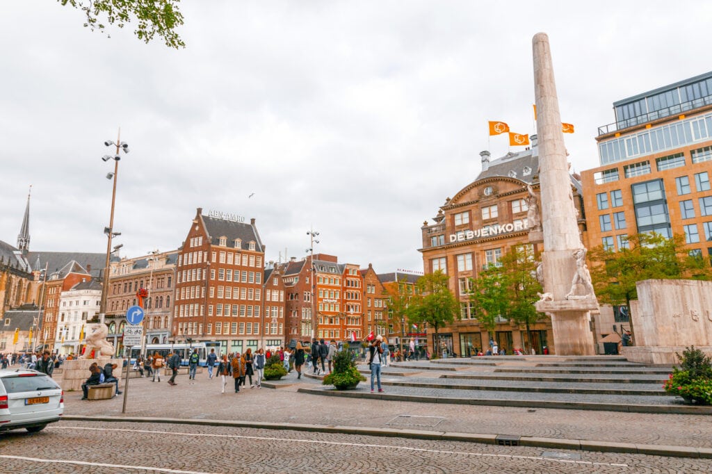 Amsterdam, the Netherlands - October 14, 2021: Buildings and people around the famous Dam Square of Amsterdam, the capital of the Netherlands. Located 750 meters south of the central station.