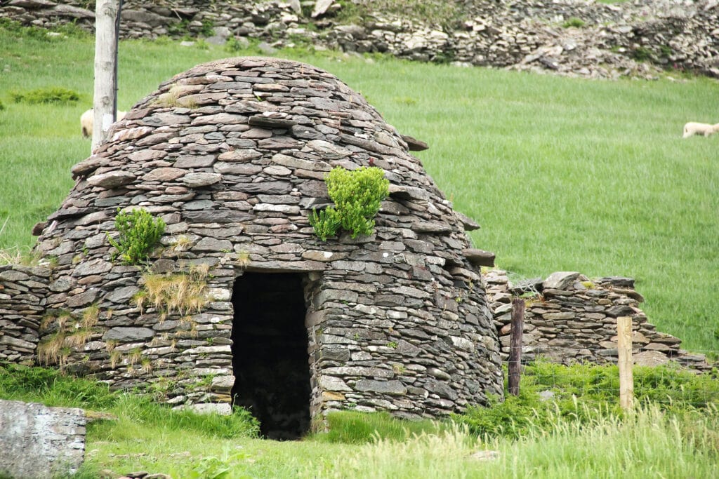 Early medieval stone-built round house clochain (beehive hut) on Dingle Peninsula, Kerry, Ireland. A Clochain is a dry-stone hut with a corbelled roof, commonly associated with the south-western Irish Fahan Group from 2000 bc