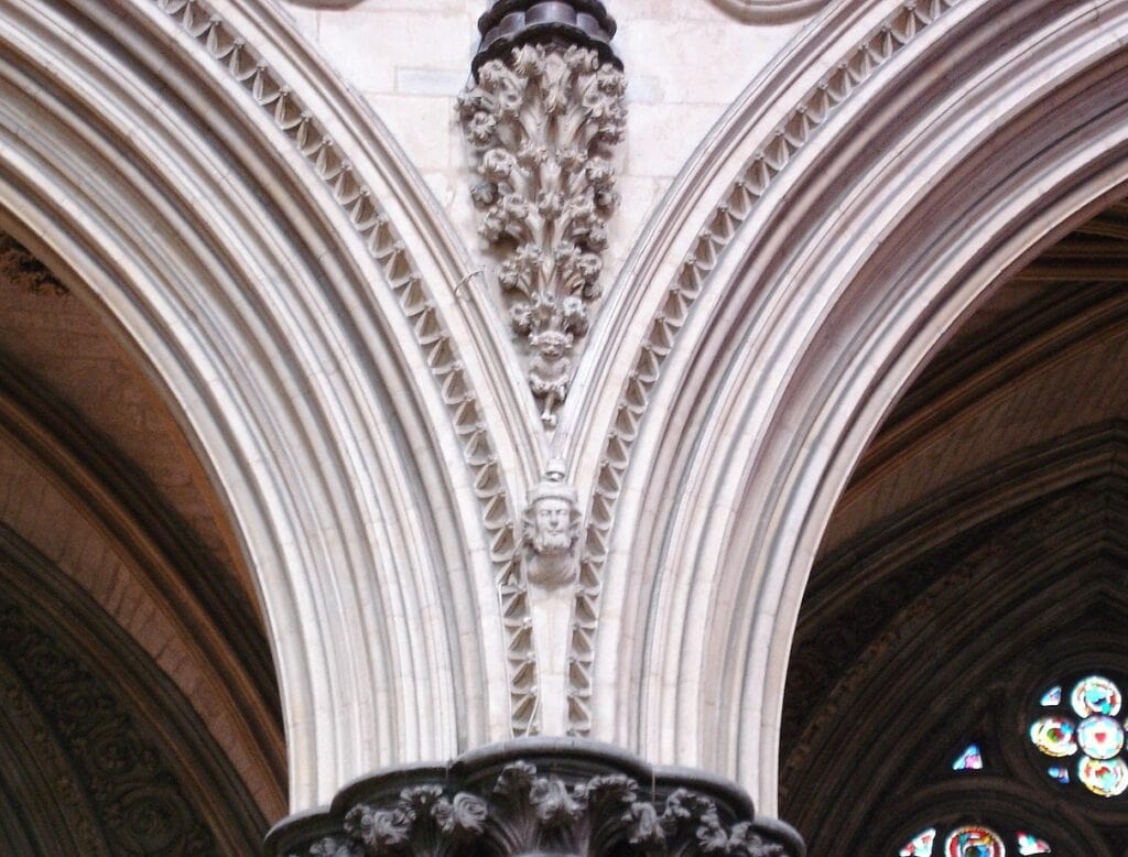 A close up of the central support between two arches of Lincoln Cathedral with the imp placed right at the bottom of the V. 