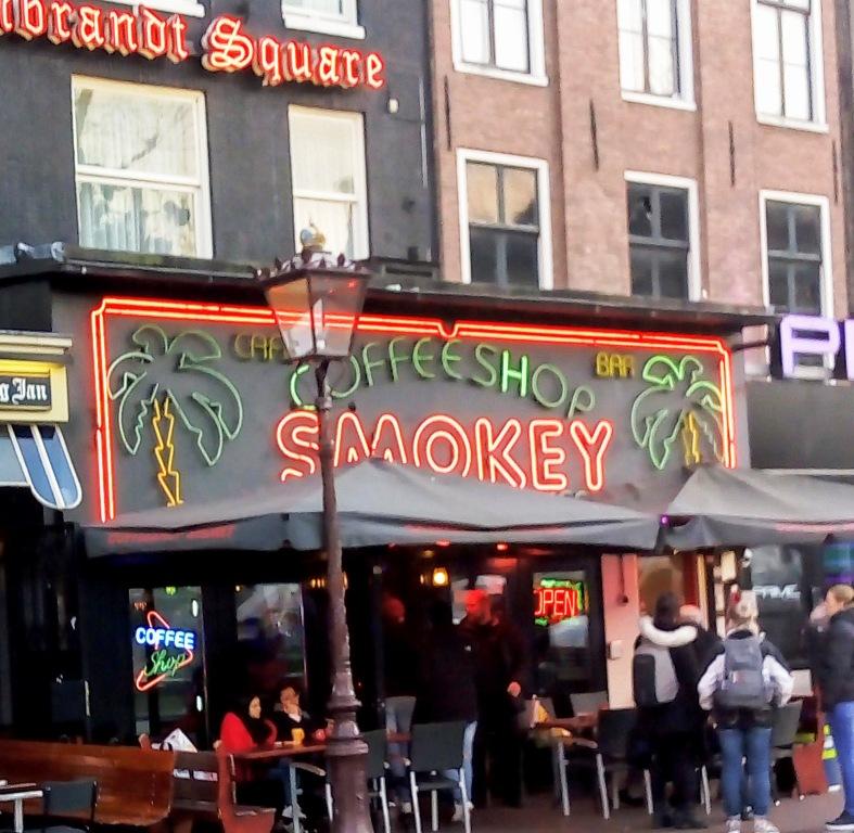 coffeeshops in Amsterdam a neon sign hangs over a coffeeshop where you can smoke legal weed in Amsterdam