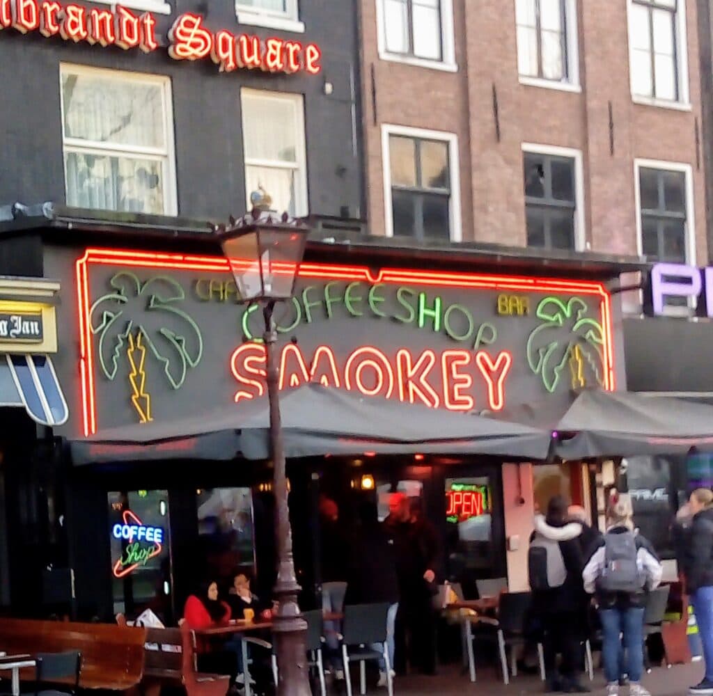 coffeeshops in Amsterdam a neon sign hangs over a coffeeshop where you can smoke legal weed in Amsterdam
