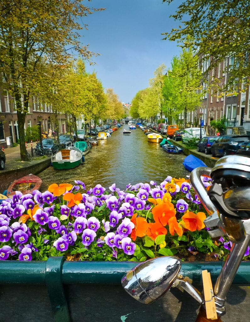 Bike on a bridge with flowers and canal. Amsterdam, Netherlands. 