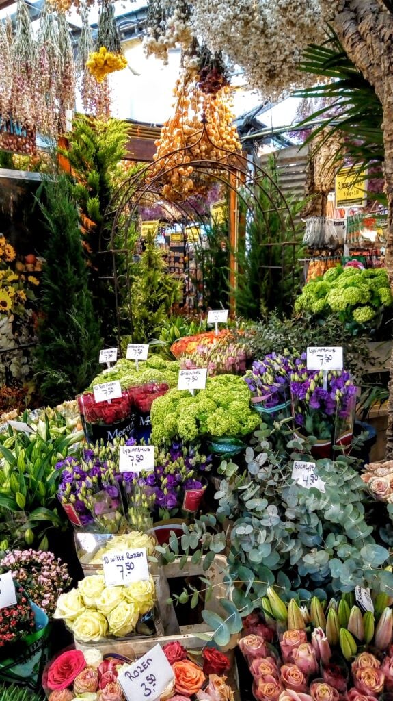 Amsterdam tips - visit one of the many flower markets in the city along the canals. A copper arch is surrounded by pots of flowers from tulips to hyacinths.