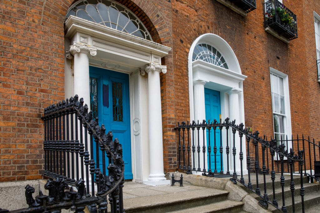 Dublin's best coffee shops - the Merrion Square Doors of Dublin. Georgian style doors with a rounded transom and blue doors with iron railings down the steps
