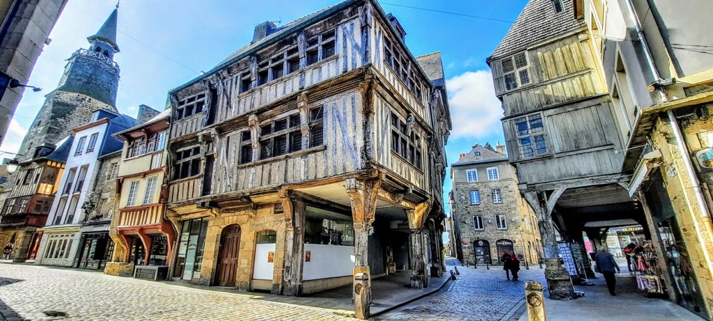 Rue du Mercier the main shopping streets in Dinan France. The medieval buildings are half-timbered and lean precariously over the street. THe lowe levels are full of boutique shops. 