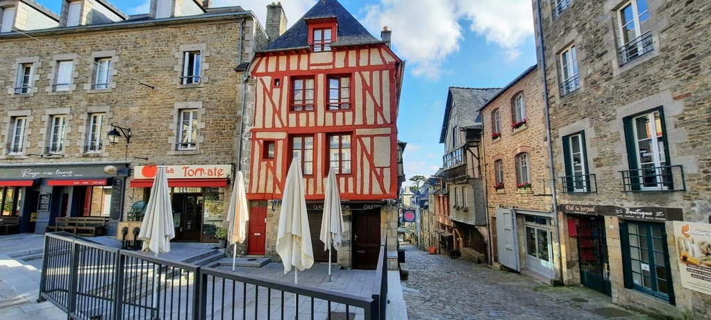 a view of Dinan France with the main tourist draw the hill down the rue de Jerzual a very steep cobbled medieval walking path down the Dinan's port on the River Rance. 